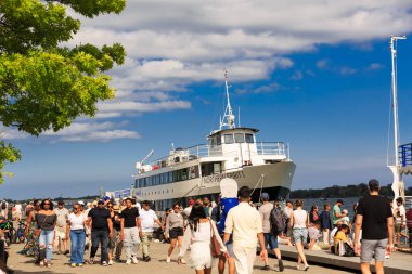Toronto, Ontario, Kanada, 28 Haziran 2025, liman önü, birçok insanın, turistlerin, ziyaretçilerin muhteşem manzarası gün batımında Ontario Gölü 'nde seyahat etmek üzere yolcu gemisine binecekler.