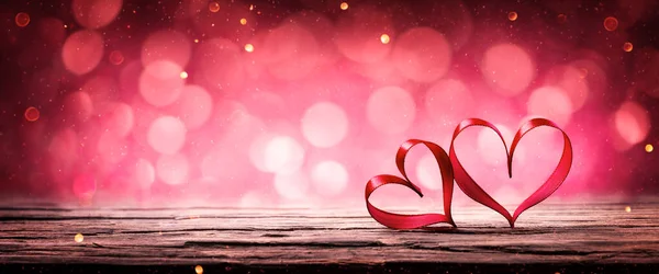 Dvě Stuhy Srdce Rustikální Dřevěný Stůl Zářící Pozadí Bokeh Valentines — Stock fotografie