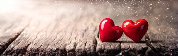 Два Красно Мраморных Стеклянных Сердца Сельском Деревянном Столе Солнечным Светом — стоковое фото