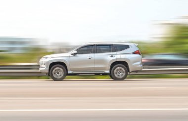 Samut Sakhon, Tayland - Nisan 2021: Mitsubishi Pajero Sport, 10 Nisan 2021 'de, Tayland Samut Sakhon' da, RamaII Yolu 'nda, bulanık arka planda, hızlı sürüş yapan gri araba..