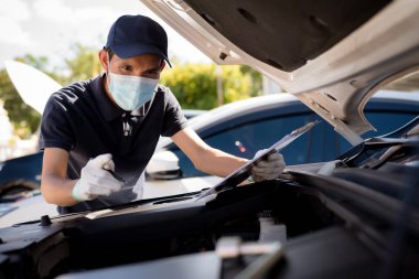 Aracın motoru kontrol edilirken panosu olan tamirci