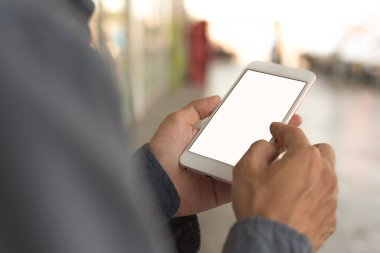 Cep telefonunun görüntüsü beyaz ekranı boşaltıyor. Adam el ele tutuşup cep telefonuyla mesaj atıyor. Reklam için arkaplan boşluğu. İş adamları pazarlama işi ve teknolojiyle iletişime geçiyor