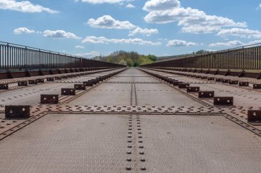 Güneşli bir bahar günü Burgundy, Fransa 'da rayların olduğu yerde kullanılmayan bir demiryolu köprüsü görüldü.