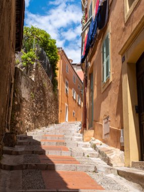 Eski Menton, Fransa 'nın renkli, dolambaçlı bir caddesinde hiç insan yok. Güneşli bir bahar gününde çekilmiş.