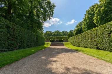 Maincy, Fransa - 21 Mayıs 2022: Fransız klasik bahçesinde düz bir çakıl geçidi (Vaux-le-Vikont). Fotoğraf, güneşli bir yaz gününün erken saatlerinde çekildi..
