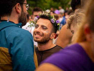 2022 Paris 'te genç beyaz bir adamın gizli bir fotoğrafı. Gay gururu kameraya bakmıyor ve kafasına çiçek tacını takmıyor.