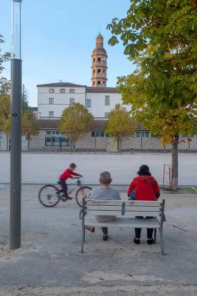 法国Cahors 2022年10月29日 两个人坐在长椅上 一个男孩在Cahors主广场的Cahors主广场上骑自行车 — 图库照片