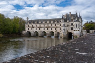 Chenonceau kalesi arka planda tanınmayan insanlarla kısmen bulutlu bir yay altında kaldı.