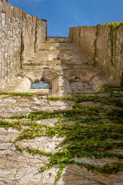 Fransa 'nın La Romieu şehrindeki Saint Peter Koleji Kilisesi' nin dış duvarının alçak açılı görüntüsü, güneşli bir günde hiç kimsenin olmadığı bir yerde çekildi..