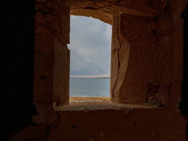 Castello Maniace, Syracuse, Sicilya, İtalya 'nın penceresinden görülen Akdeniz. Fırtınalı bir kış gökyüzü altında hiç insan olmadan çekildiler..