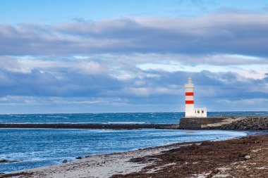 Atlantik Okyanusu 'nun bir parçası olarak İzlanda Denizi kıyısındaki deniz feneri. Holmsvollur, Sudurnesjabaer, İzlanda.