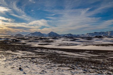 Kuzeydoğu İzlanda dağlarında günbatımı ve sonbaharın ilk karı.
