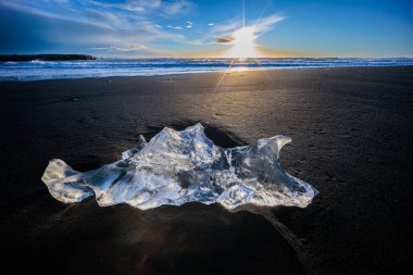 Loose segments of glacier washed out of Jokulsarlon glacial lake onto Diamond Beach on Iceland, North Atlantic clipart