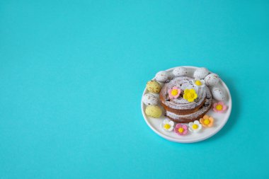 Mavi arka planda yumurta ve şeker çiçekli Paskalya desenli çörekler.
