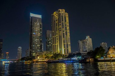 Aydınlatılmış gökdelen binası ve geceleri Chao Phraya yakınlarındaki Bangkok 'un ufuk çizgisi