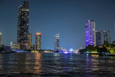 Aydınlatılmış gökdelen binası ve geceleri Chao Phraya yakınlarındaki Bangkok 'un ufuk çizgisi