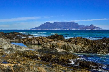 Cape Town 'da kayaları ve Atlantik okyanusu olan bir masa.
