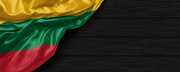 Siyah ahşap arka planda Litvanya bayrağını kapatın.