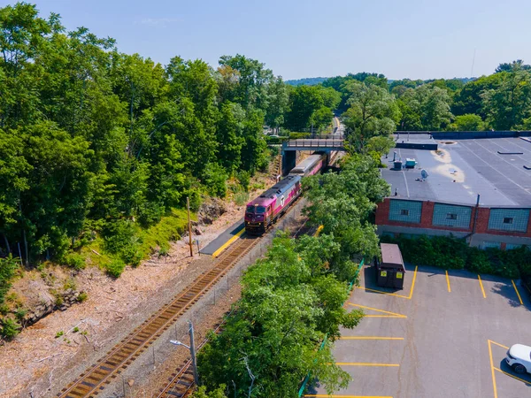 stock image MBTA Commuter Rail #2033 MPI HSP46 locomotive leaving from Wellesley Square Station, Wellesley, Massachusetts MA, USA.