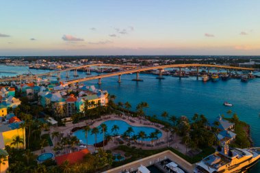 Günbatımı manzaralı liman villaları ve Bahamalar Cennet Adası 'ndaki Nassau Limanı' ndaki Paradise Island Köprüsü..