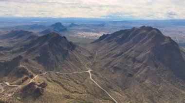 Tucson Dağları 'ndaki Halkakuyruk Tepesi ile Golden Gate Tepesi arasındaki Yetman Yolu, ABD' nin Tucson kentindeki Arizona AZ kentindeki Saguaro Ulusal Parkı yakınlarındaki Gates Geçidi 'nden Sonoran Çöl manzarası ile kesişiyor.. 