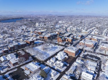 ABD 'nin Massachusetts eyaletinin tarihi kenti Natick' te kışın Central Caddesi 'nde ilk Cemaat Kilisesi ve Kasaba Genel Görünümü.