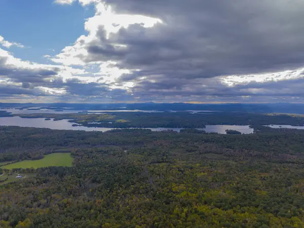 Moultonborough, New Hampshire NH, ABD 'den sonbaharda bulutların arasından geçen Winnipesaukee Gölü' nün hava manzarası.. 