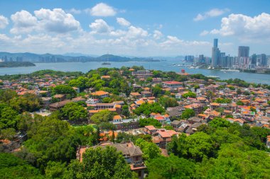 Günışığı Kayası 'ndan (Lit-kong-giam, Riguangyan) Gulangyu tarihi hava manzarası, arka planda Xiamen modern silueti, Fujian, Çin. Gulangyu UNESCO 'nun Dünya Mirası Bölgesi.