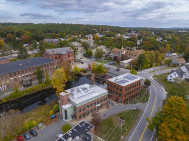 Whitin Machine Works Mill 'in ana caddedeki hava manzarası, ABD' nin Massachusetts MA eyaletinin Northbridge kasabasındaki tarihi Whitinsville kasabasında sonbaharda yeşillik ile boyandı.. 