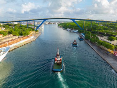 Willemstad tarihi şehir merkezi Curacao 'da Koningin Julianabrug köprüsü ile Sint Anna Körfezi' nde römorkör görüntüsü. Tarihi Willemstad UNESCO 'nun Dünya Mirası Bölgesi. 