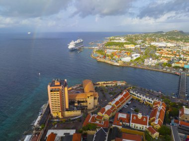 Willemstad, Curacao 'daki St. Anna Körfezi ağzındaki Fort Amsterdam ve Waterfort da dahil olmak üzere Willemstad üzerindeki gökkuşağı manzarası. Tarihi Willemstad UNESCO 'nun Dünya Mirası Bölgesi. 