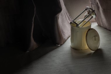 Çöp tenekesinde kum saati ya da kum saati pencere minderlerinin üzerinde açık kapaklı güzel perdenin ilk ışıklarıyla birlikte oturma odasında. Metin için boşluk, Seçici odak.