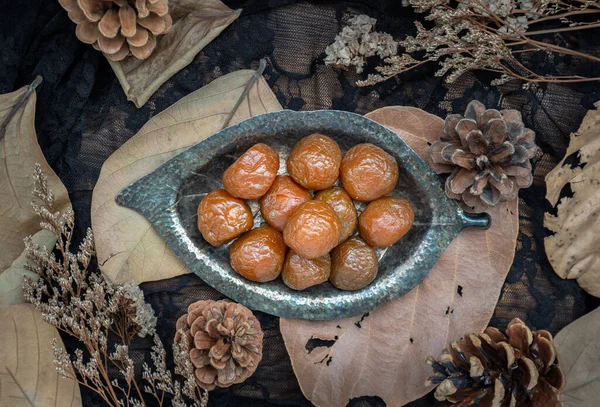Küçük gümüş yaprak şeklinde tabakta üç aromalı Çin eriği (korunmuş meyveler). Tadı ekşi, tuzlu ve tatlı. Üst Görünüm, Seçici Odaklanma.