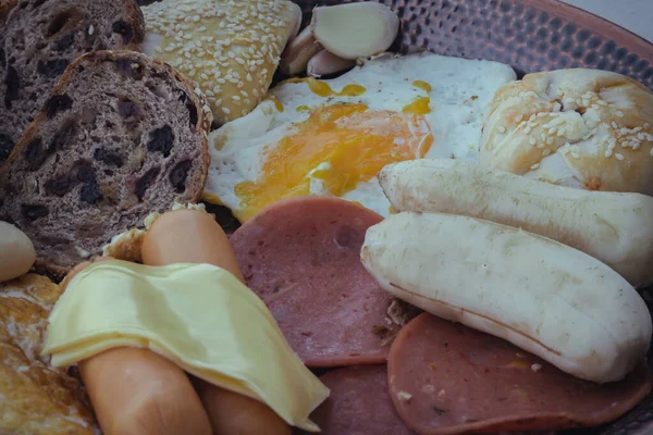 stock image Homemade breakfast with Fried sausages, Bologna sausages, Cheese, Fruit breads, Roasted pies, Fried egg, Omelette, Banana, Chocolate cookie and Garlic. Healthy food concept, Selective focuse.