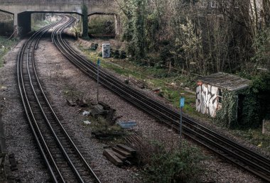 Londra, İngiltere - 06 Mart 2019 'da köprünün altından geçen iki eski tren yolu. Londra 'daki güzergah ve tren raylarının perspektifi, Seçici odak.