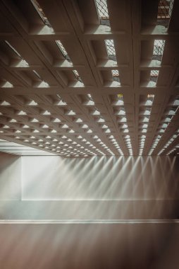 Güneş ışığı eski spor salonunun ışık kanallarından parlıyor. Beton duvarlarda güneş ışığının dışarıdan geçeceği delikler, ışık ve gölge konsepti, metin için boşluk, Seçici Odaklanma.