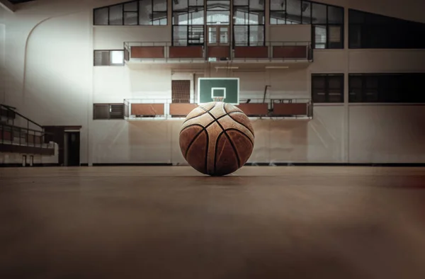 Bangkok, Thailand - Nov 27, 2022 : Basketball ball placed on court floor in the basketball gym. View from Empty basketball gym, Space for text, Selective focus.