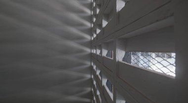 Güneş ışığı eski spor salonunun ışık kanallarından parlıyor. Beton duvarlarda güneş ışığının dışarıdan geçeceği delikler, ışık ve gölge konsepti, metin için boşluk, Seçici Odaklanma.