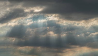Güneş ışınları bulutların arasından geçiyor ve parlıyor. Gökyüzüne karşı ilginç bir ışık deseni oluşturuyor. Metin için boşluk, Seçici odak.