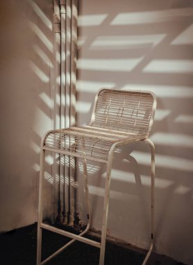 The stand alone chair is affected by Sunbeam shine through in the morning. Vintage tone, Copy space, Selective focus.