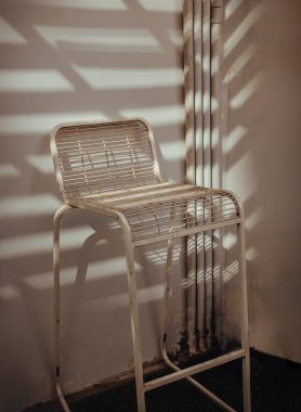 The stand alone chair is affected by Sunbeam shine through in the morning. Vintage tone, Copy space, Selective focus.