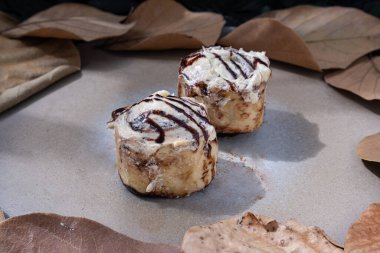 Koyu arkaplanlı seramik tepside krem peynirli iki yumuşak çikolatalı çörek. Lezzetli yemek konsepti, metin için alan, Seçici Odaklanma.