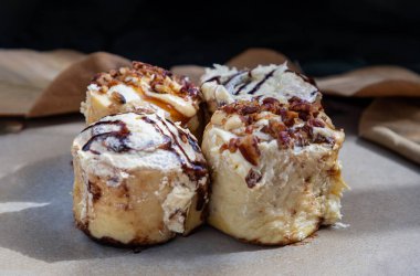 İki tane krem peynirli kremalı çörek ve iki tane karamelli fındıklı krema ve seramik tepside cevizli fındıklı. Lezzetli yemek kavramı, Seçici Odaklanma.