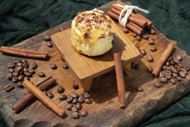 Çikolata (yumuşak çikolatalı çörek) üzerinde krem peynirli krema ve üzerinde koyu arkaplan üzerine kahve çekirdekleri olan tarçınlı kahve. Seçici odak.