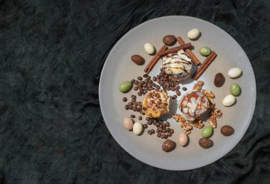 Fırın, çubuk kurabiye, ceviz, renkli yumurta, kavrulmuş kahve çekirdekleri ve koyu arkaplanlı tarçın tepsisi. Metin, Üst Görünüm ve Seçici Odaklanma için boşluk.