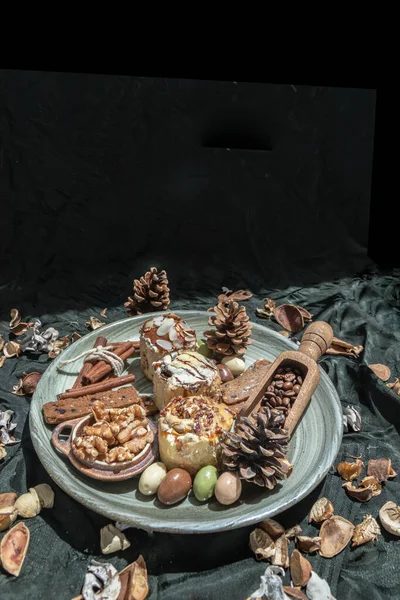 复活节烘焙 棒饼干 核桃和彩蛋与松果陶瓷盘与黑暗背景 案文空间 选择性重点 — 图库照片