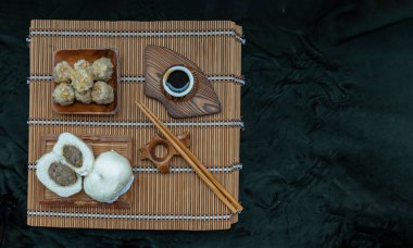 Buharda pişmiş domuz etli çörek ve domuz shumai ya da Çin buğulamalı hamur tatlısı. Ekşi sos ve bambu buharlı tahta çubukla servis ediliyor. Çin Dim Sum. Üst görünüm, metin için boşluk, Seçici Odaklanma.