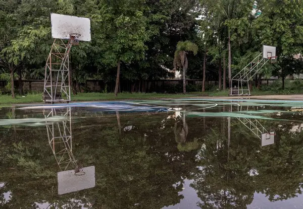 两个装有铁环和白网的篮球板背板显示了他们在公园里旧篮球场上的雨水中的倒影 案文空间 选择性重点 — 图库照片