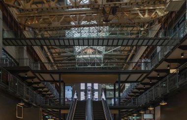 Londra, İngiltere - 13 Ekim 2023 - Yeni Battersea Enerji İstasyonu 'ndaki bir sanat tesisini askıya alan iki iç yürüyen merdiven ve eski bir vinç görüntüsü şimdi bir alışveriş ve eğlence merkezi olarak yeniden geliştirildi. Metin için boşluk, Seçici odak.