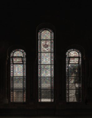 Londra, İngiltere - 01 Kasım 2023 - Yükseklik pencerelerindeki kişniş boyalı camlar Doğal Tarih Müzesi 'nin ana salonundaki büyük taş kemerler içinde yer alıyor. Lekeli cam pencerelerin deseni, Viktorya döneminden kalma vitray, metin için alan, 